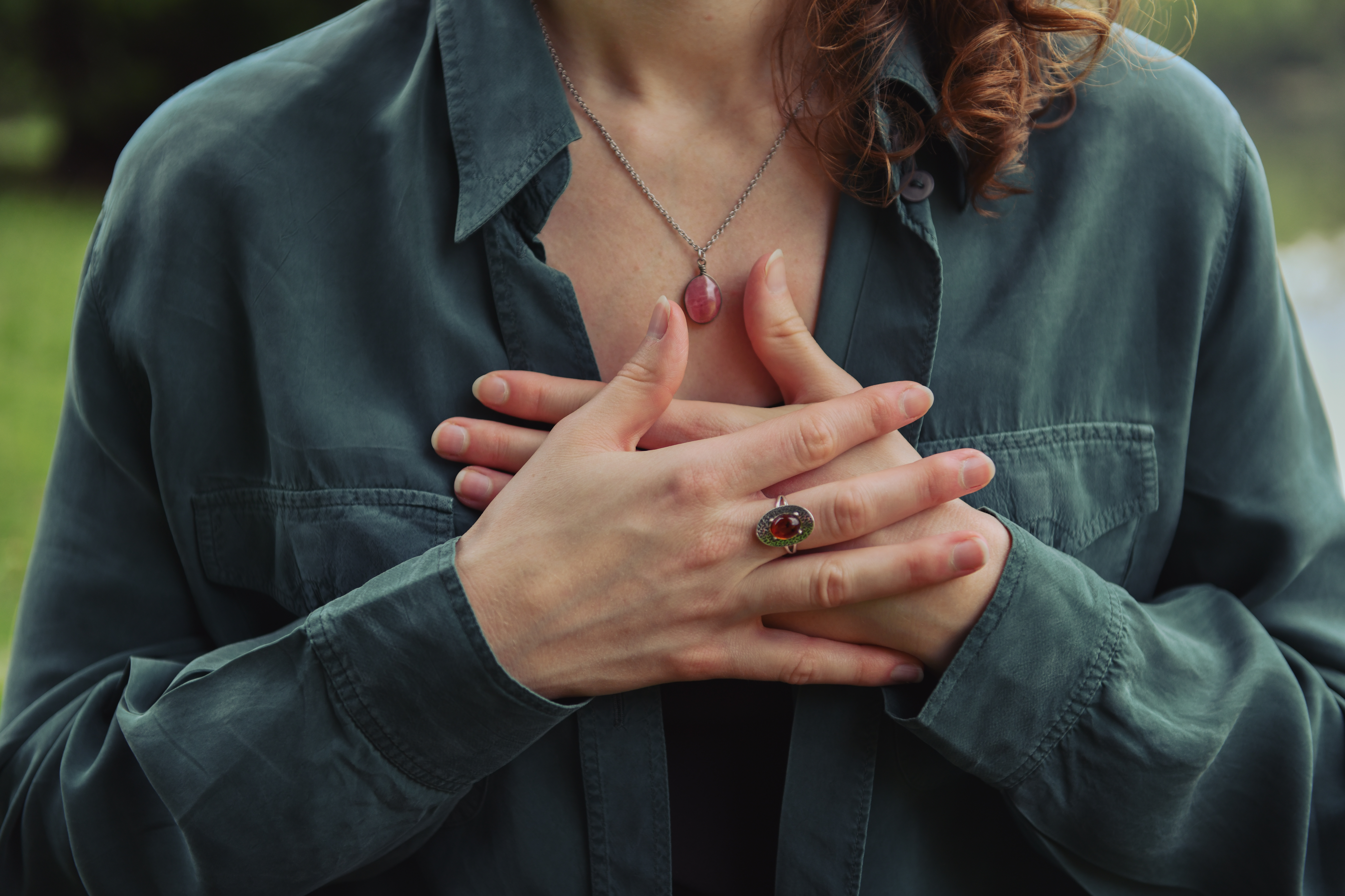 Zoom sur l'apposition des mains d'une femme, apposées l'une contre l'autre, contre le cœur. Elle médite en pleine conscience.